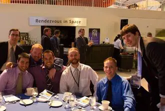 A group of people sitting at a table with food.