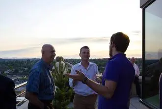 Three men are talking to each other outside.