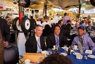 A group of people sitting at tables with food.