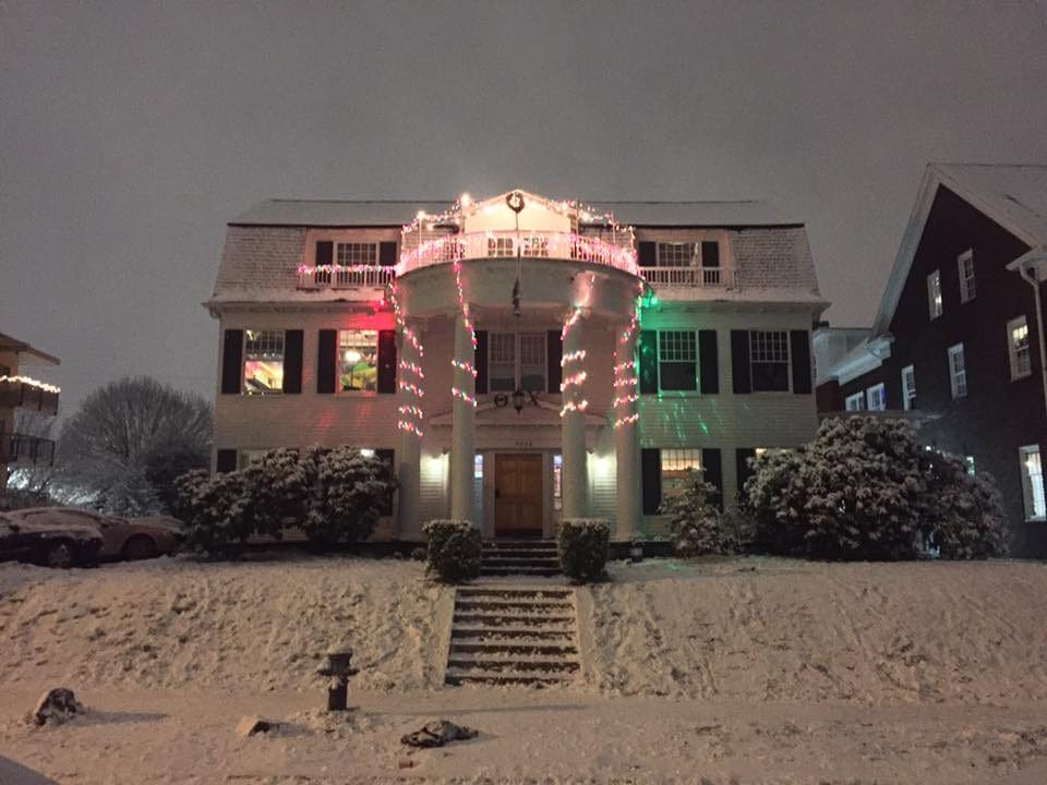 A large white house with lights on the front of it.