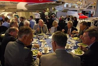 A group of people sitting at a table with plates.