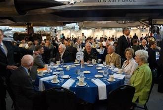 A group of people sitting at tables with plates.